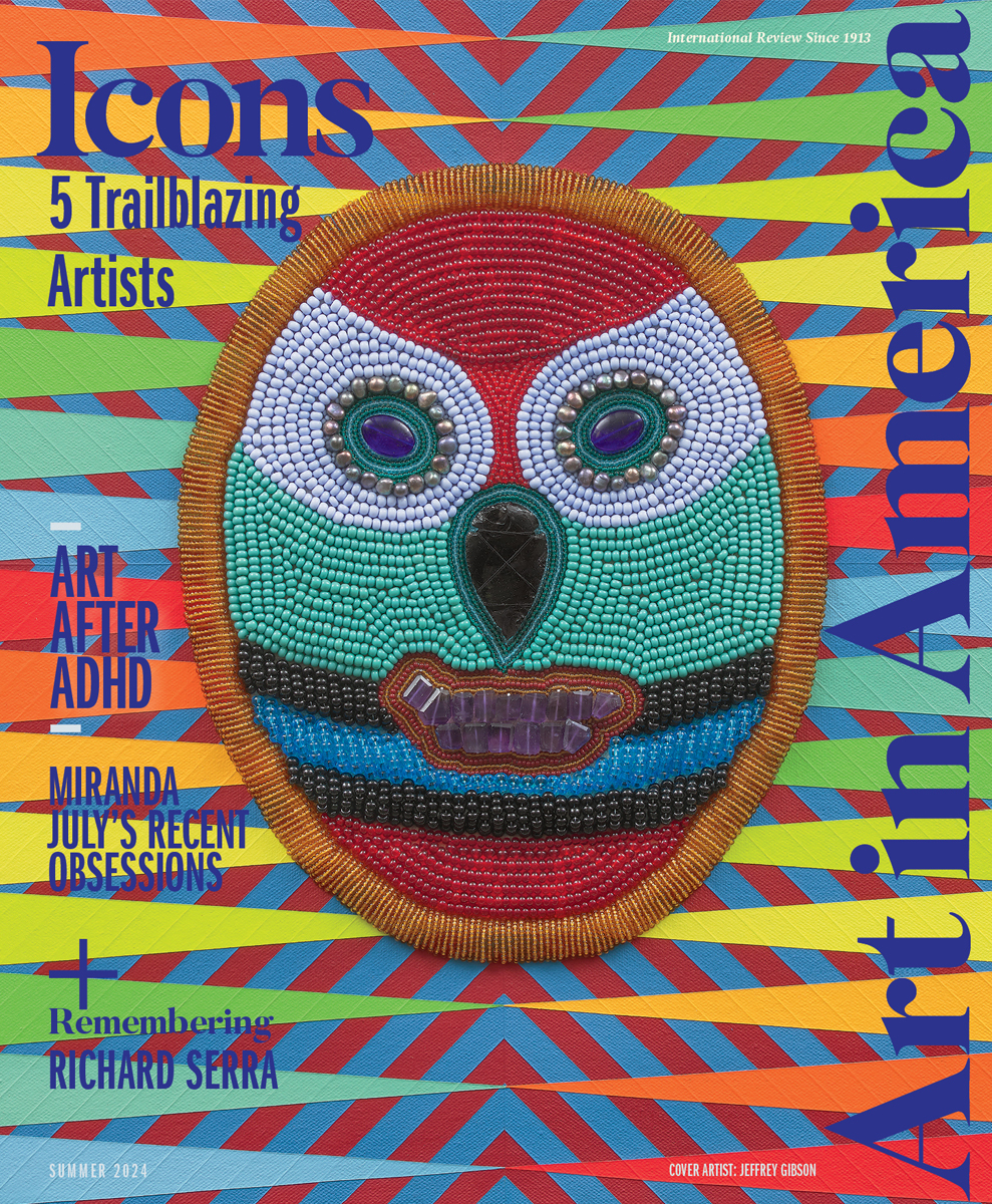 A magazine cover with "Art in America" along the side of a beaded face mask atop a colorful canvas comprised of triangles and vector lines.