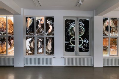 Stained glass windows resembling abstracted animal-like forms in shades of black.